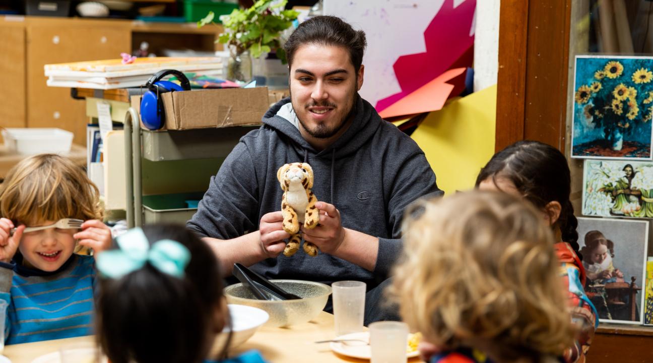 Early Childhood Professional playing with four children sitting around a table