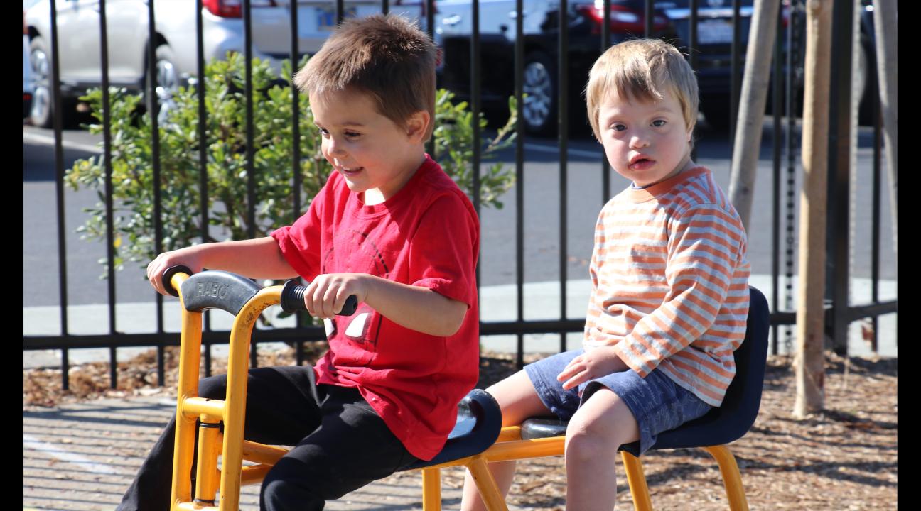 Two preschool children riding together on a bike
