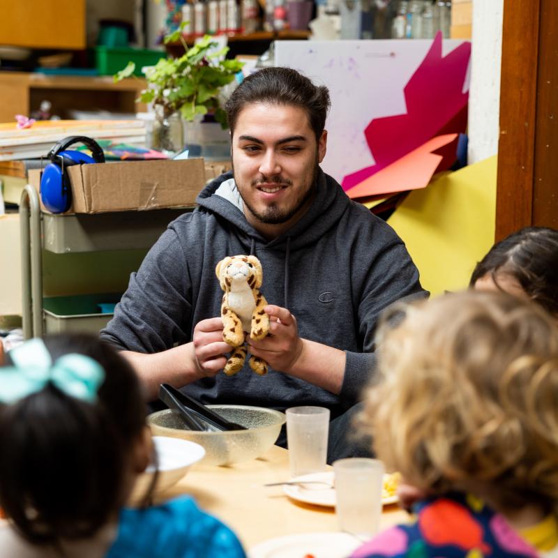 Early Childhood Professional playing with four children sitting around a table