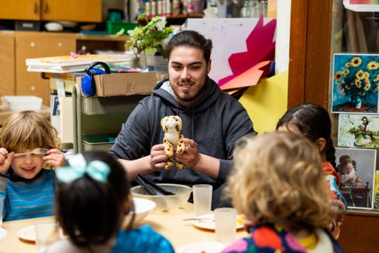 Early Childhood Professional playing with four children sitting around a table